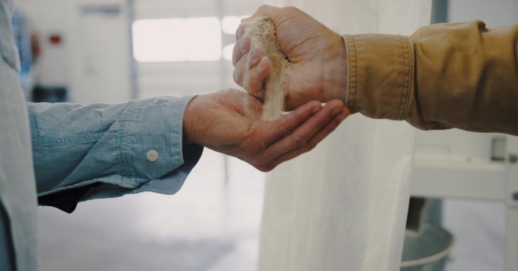 Hands exchanging flour, from Cairnspring Mills